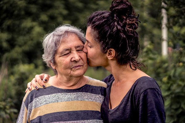 a woman kissing her elderly mother