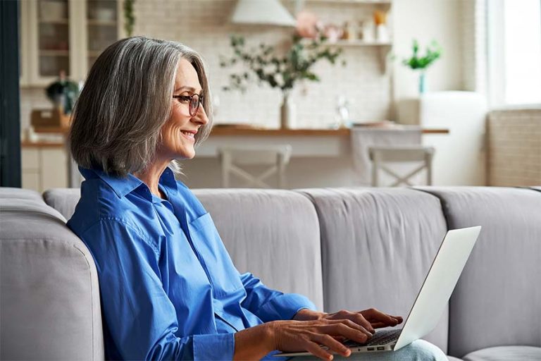 woman on gray sofa with laptop 